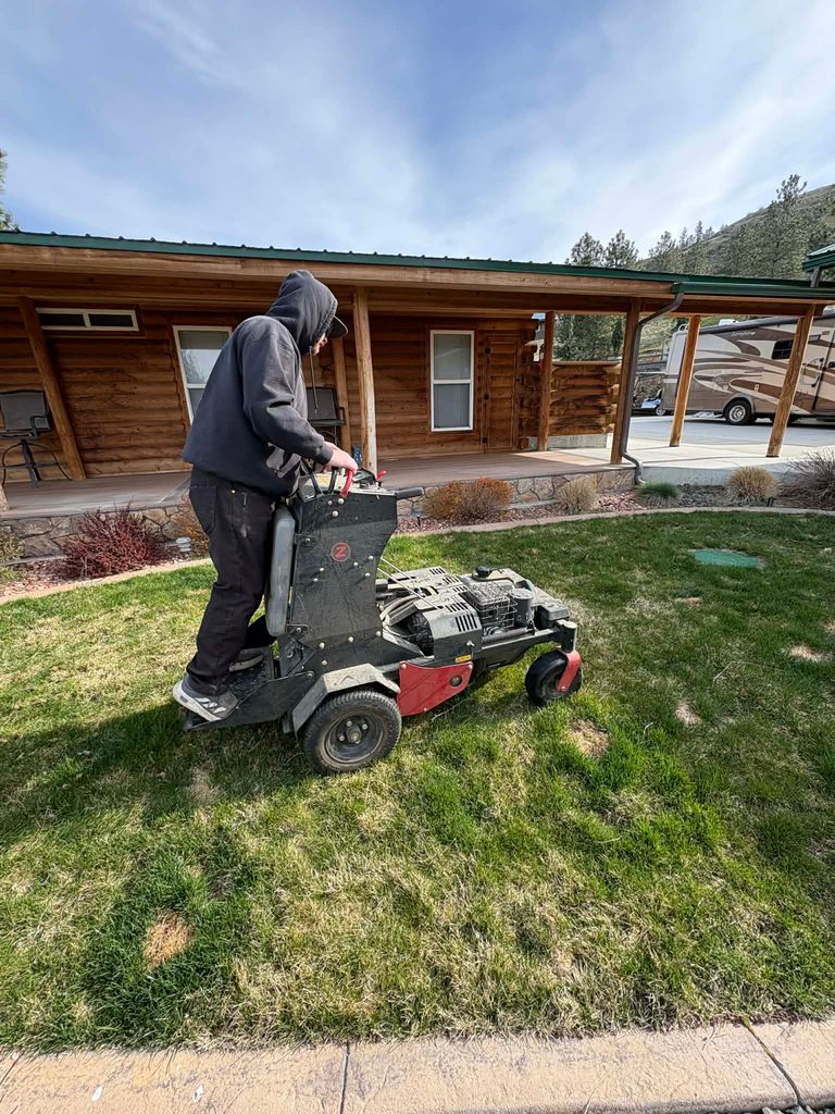 Core aerating a lawn with a stand-on aerator