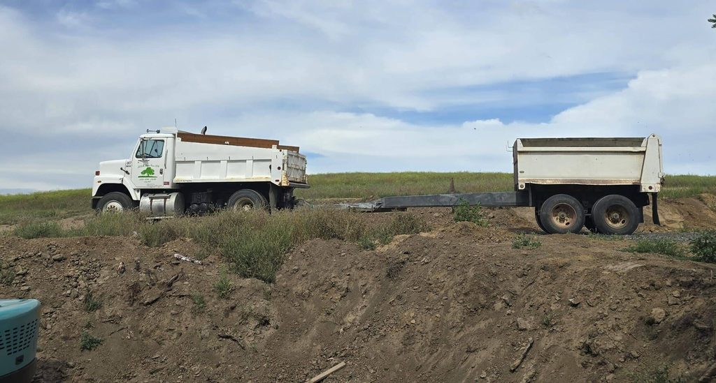 MKB Lawncare dump trucks hauling material on a job site