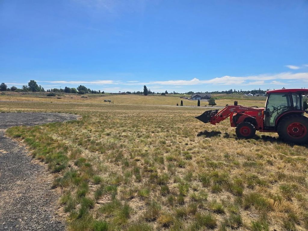 MKB Lawncare tractor with a rotary cutter mowing a large field