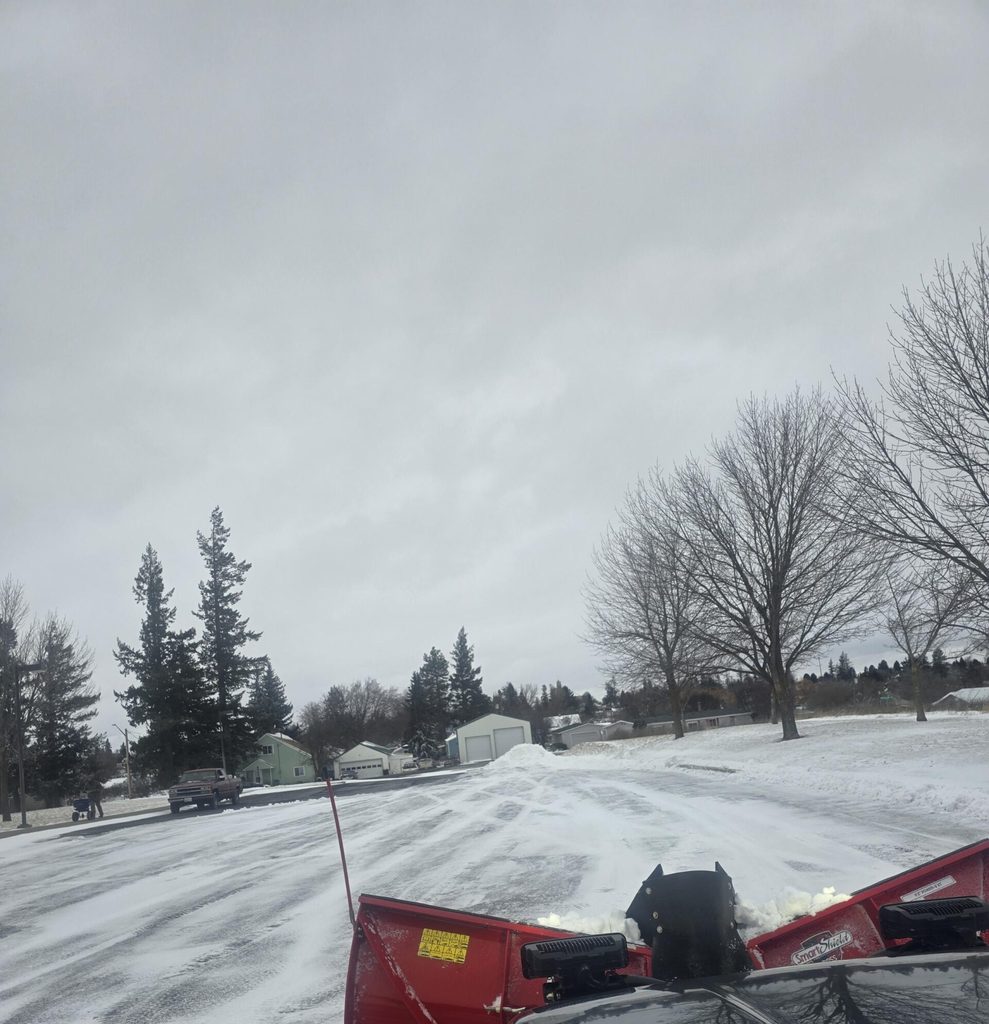 Snow plowing a driveway and parking area during winter property maintenance